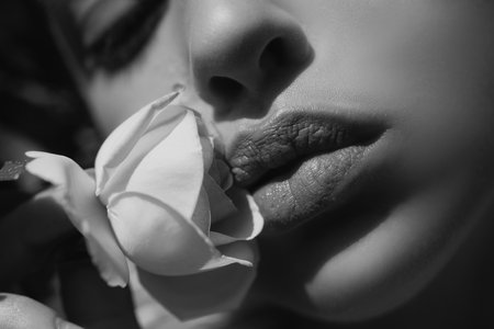 Beautiful woman lips with spring rose. Beautiful lips Close-up. Makeup. Lip matte lipstick. Sexy lips.の写真素材