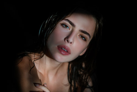 Sexy gorgeous woman with shadows on beautiful face on black studio. Tender girl, tenderness.