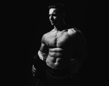 Athletic young male model showing his perfect naked body. Sexy man with muscular torso.の写真素材