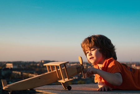Kids playing with vintage wooden airplane outdoors. Portrait of children against summer sky background. Travel and freedom concept. Summer holidays with children.の写真素材