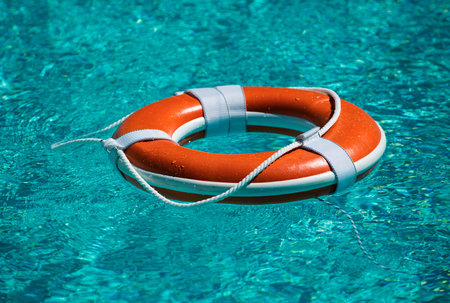 Lifebuoy in swimming pool. Summer vacation concept. Life buoy in water. Help concept.