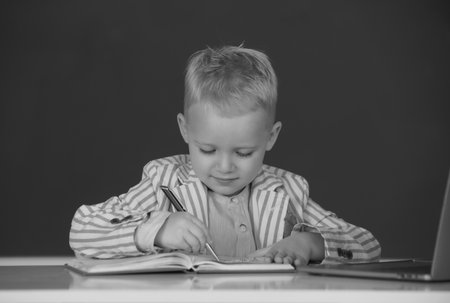Little schoolboy study in a classroom at elementary school. Kid writing in class.の写真素材