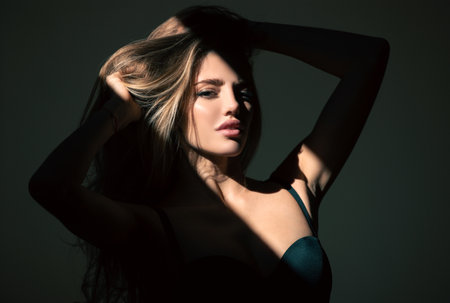 Sexy gorgeous woman with shadows on beautiful face on black studio. Sensual girl with art shadow light.の写真素材