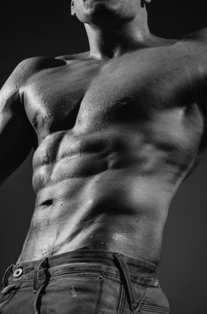 Muscle strong man guy in jeans on gray isolated background. Ideal fit body.の写真素材