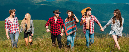 Happy friends walking on mountain. Friends spring travel vacation banner. Group of hikers on the top of the mountain. Friendship freedom summer holiday concept.の写真素材