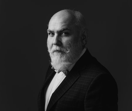 Senior Man. Close up portrait of an elegant senior man with grey hair isolated on black background.