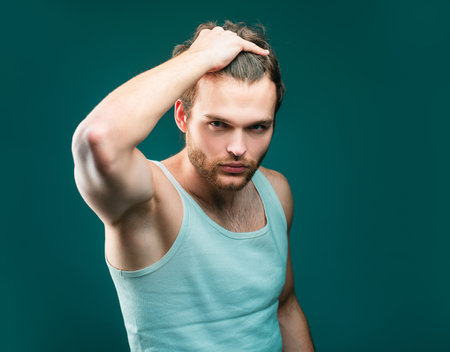 Man hair style and trend. Male beauty concept. Stylish haircut, hairstyle. Handsome guy with confident face.の写真素材
