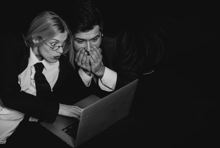 Business people. Business colleagues couple isolated over black background using laptop computer.の写真素材
