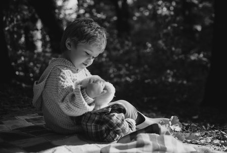 Cute Boy with teddy bear sit on park. Happy kids. Cute picture for childrens ads. Freedom Concept.の写真素材