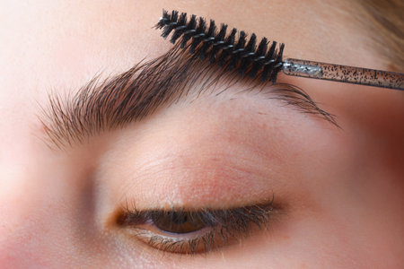 Perfect eyebrows. Close up of woman getting eyebrow make-up. Macro applying cosmetics on her eyebrow...