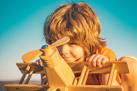 Dreams of travel. Development, growth, dreams and plans. Kid dreams of future. Kid pilot dreaming. Childhood dream concept. Blonde cute daydreamer child dream on fly. Dreams and imagination.の写真素材