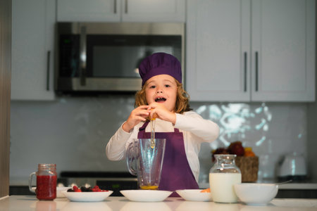 Cooking in kitchen. Chef cook child having fun preparing a cake in kitchen at home. Kid boy in chef...