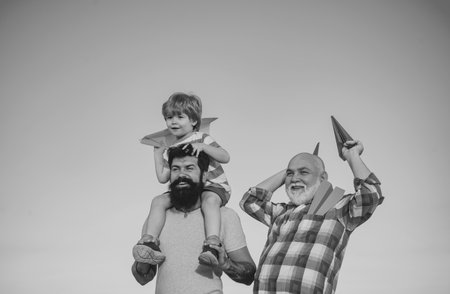 Happy man family have fun together. Childhood concept. Leisure activity. Son father and grandfather playing on blue summer sky. Fathers day concept.の写真素材