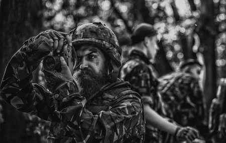 Photojournalist documenting war, military press photographer. Military operation. Shooting with assault rifle and machine gun, attacking enemy. Military photo, army background.の写真素材