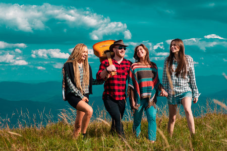 Group of friends on country walk on a summer day. Young people hiking in countryside, summer outdoor. Group of youth at summer festival.の写真素材