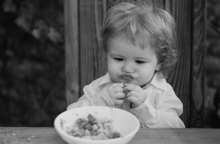 Funny baby eating kids food. Healthy kids breakfast.の写真素材