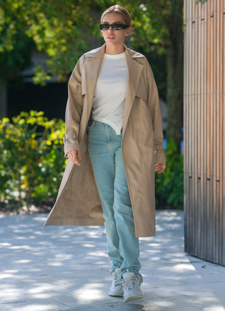 Coat. Outdoor lifestyle portrait of pretty young fashion model in urban background. Outdoor elegant fashionable woman walking in street. Summer lifestyle portrait of stylish girl wearing trendy outfit.の写真素材