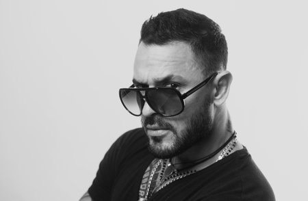 Handsome confident man. Serious guy posing in studio. Fashion young male model with sunglasses and confident face. Close up face, portrait.の写真素材