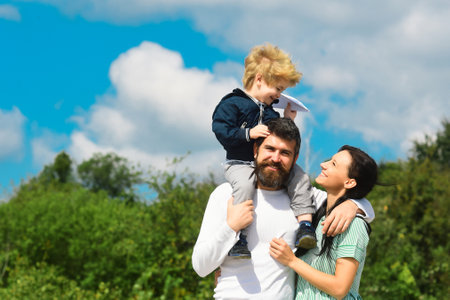 Happy family mother, father and child with toy paper plane. Happy family with children on weekend. Young parents and their child are very happy.の写真素材