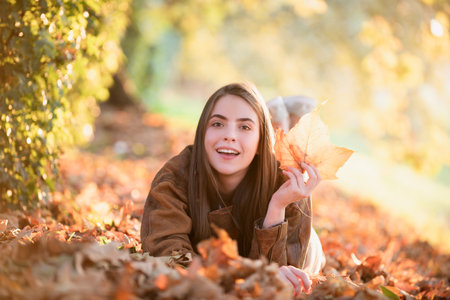 Young woman in autumn park. Warm sunny weather. Fall concept. Hello autumn. Happy woman with autumn...