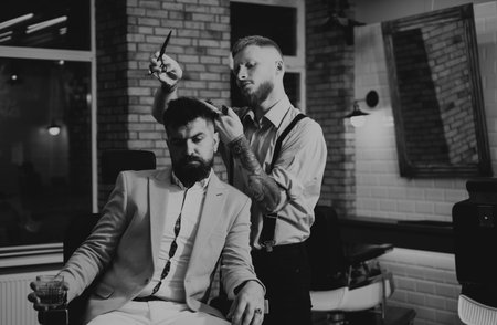 Hair Preparation is just for dashing chap. Bearded stylish barber shop client. Bearded client visiting barber shop. Barber scissors. Beard styling and cut. Making haircut look perfect in barber shop.の写真素材