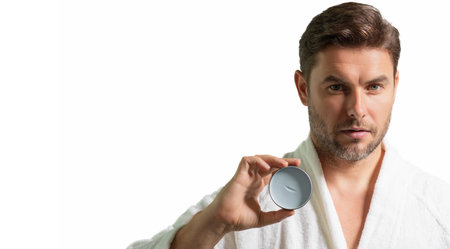 Sexy bearded man care of skin. Unshaven man with bristle and perfect skin. Male beauty and skincare concept. Man cosmetic, skin treatment. Morning hygiene. White isolated banner with copy space.の写真素材