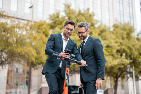 Colleagues in suit talking outdoor. Businessmen walking and talking outdoor in New York city. Confident employee talk with colleague explain new bysiness idea.の写真素材