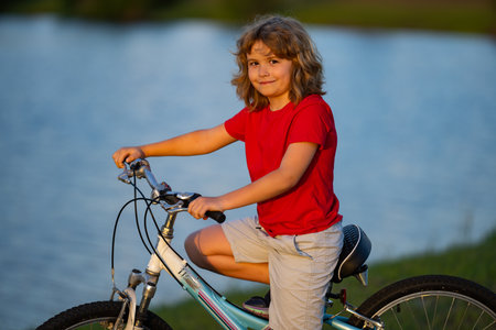 Child riding bicycle. Little kid boy on bicycle along bikeway. Happy cute little boy riding bicycle in summer park. Child cycling on bicycle. Kid riding bike.の写真素材