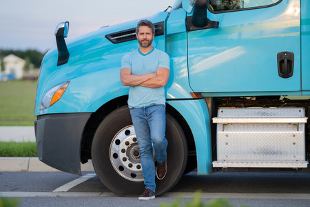 Men driver near lorry truck. Man owner truck driver. Millennial trucker. Trucking owner. Transportation industry vehicles. Handsome man posing in front of truck.の写真素材