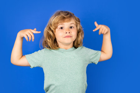 Look at my. Funny little kid pointing at my on blue isolated background.の写真素材