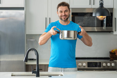 Man chef cooking food in pan pot in kitchen. Process of preparing gourmet dish. Man cooking at home...