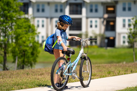 Child on bicycle. Boy in a helmet riding bike. Little cute caucasian boy in safety helmet riding bike in city park. Child first bike. Kid outdoors summer activities. Kid on bicycle. Boy ride a bike.の写真素材