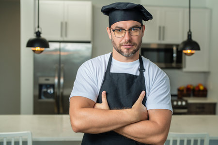 Handsome middle age man in chef uniform at kitchen. Cooking and culinary. Restaurant menu concept....