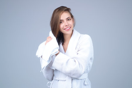 Beautiful woman wiping hair. Girl wrapped in towel with wet hairs. Natural hair. Smiling girl enjoying pure fresh hair, dry wet hair with a towel. Beauty haircare concept. Morning hairs care.の写真素材