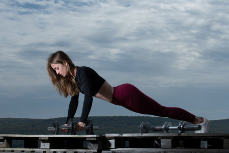 Booty fit girl lifting dumbbells. Perfect sporty body of sexy fitness woman. Sexy slim waist....