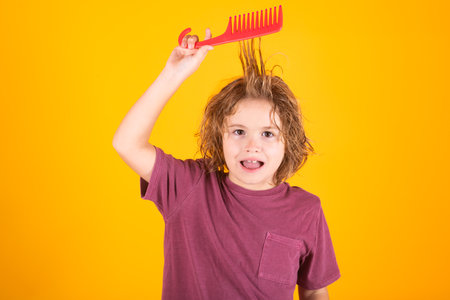Child combing hair after shower. Little kid combing hair, isolated studio background.