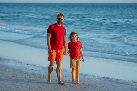 Father and son holding hands walking on beach. Happy family. Fathers day. Love family, father and a...
