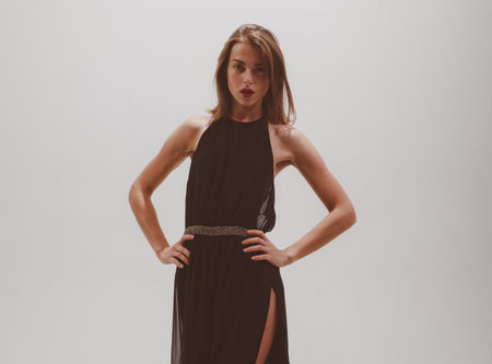 Young sexy beautiful brunette lady in gorgeous black dress. Fashion photo.の写真素材