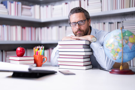 Teachers day. Teacher in school classroom. Knowledge and education with middle aged teacher. Millennial teacher with book. Man teaching lesson in class. Teachers from university exam. College teacher.の写真素材