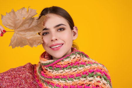 Studio portrait of young woman with autumn fall leaves.の写真素材