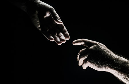 Men holding hands isolated on black. Connection and human relations. Male hands rescue. Friendly handshake, friends greeting, friendship. Rescue, helping gesture or hands. Helping hand. Hand creation of adam.の写真素材