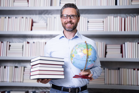 Teachers day. Teacher in school classroom. Knowledge and education with middle aged teacher. Hispanic teacher with book. Man teaching lesson in class. Teacher from university exam. College teachers.の写真素材
