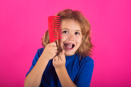 Tangled kids hair. Little child boy combing hair, isolated background.の写真素材