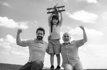Three generations of men together, portrait of smiling son, father and grandfather with a toy...