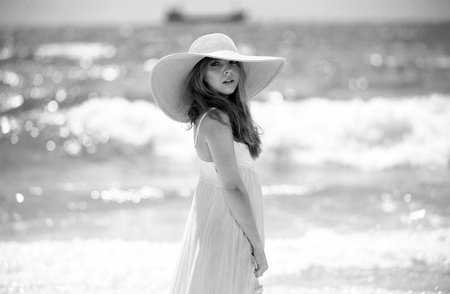 Fashion model posing on the beach. Summer dress fashionable woman clothes. Young beautiful hipster woman on tropical vacation, summer trend style.の写真素材