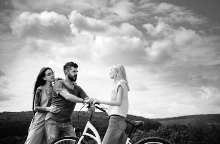 Friends on bicycle in the park. Group adventure with happy and smiling. Woman riding on bike on road along trail on mountain. Camping, jungle adventure concept.の写真素材