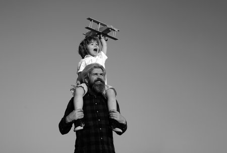 Father and son playing with wooden airplane. Sweet childhood.の写真素材