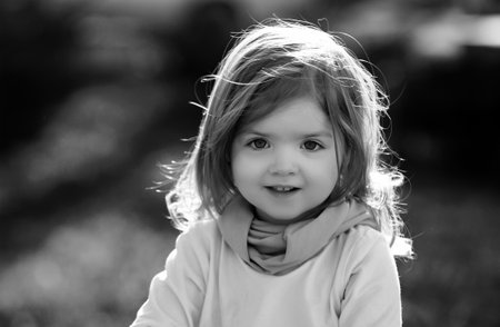 Baby child on the green grass in summer park. Baby face closeup. Funny little child close up...