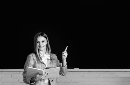 Female student with pointing finger in university, school education, Young woman study in college classroom.の写真素材