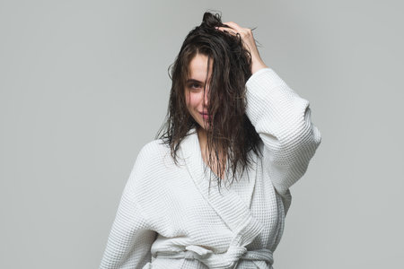 Young brunette woman with nourished long hair, studio shot. Girl touching her hair.の写真素材